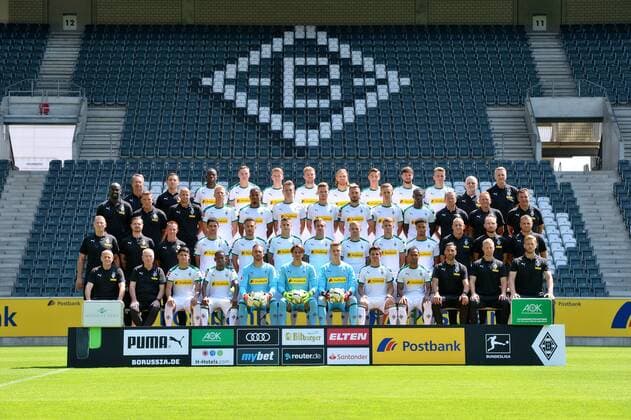 VfL Borussia Mönchengladbach 1 BL 2018 2019 Team photo Top row v li Head of Medicine and Prevention Dr Andreas Schlumberger Team physician Dr Ralf Doyscher Denis Zakaria Florian Mayer Andreas Poulsen Christoph Kramer Michael Lang Florian Neuhaus Tobias Strobl Louis Jordan Beyer Team doctor Dr Heribert Ditzel Team doctor Dr Stefan Hertl Second Serie von oben v li Transitional coach Otto Addo Goalkeeping coach Uwe Kamps Goalkeeping coach Steffen Krebs Oscar Wendt Alassane Plea Matthias Ginter Nico Elvedi Josip Drmic Torben MuÌsel Mamadou Doucoure Co Coach Frank Geideck Co Coach Dirk Bremser Head coach Dieter Hecking Second row from below v left Physiotherapist Dirk MuÌller Physiotherapist Benedikt Beans Masseur Adam Szordykowski Lars Stindl Fabian Johnson Laszlo Benes Patrick Herrmann Tony Jantschke Michael Cuisance Keanan Bennetts Supervisor Christian Rieger Physiotherapist Holger Wagner Senior Physiotherapist Hendrik Schreiber Bottom row v left Attendance Manager Marcus Breuer Supervisor Rolf HuÌlswitt Julio Villalba Ibrahima Traore Tobias Sippel Yann Summer Moritz Nicolas Jonas Hofmann Raffael Athletic Trainer Alexander Mouhcine Athletic Trainer Quirin Löppert Athletic Trainer Markus MuÌller