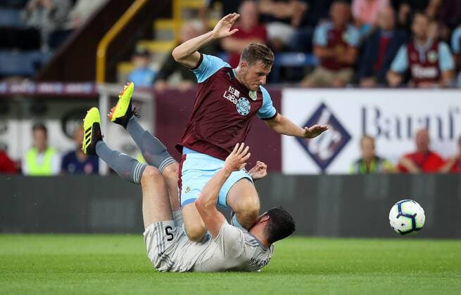 Football - 2018 2019 Europa League - Second Qualifying Round, Second Leg: Burnley (1) vs. Aberdeen (1). Chris Wood of Burnley and Scott McKenna of Aberdeen at Turf Moor. COLORSPORT LYNNE CAMERON 