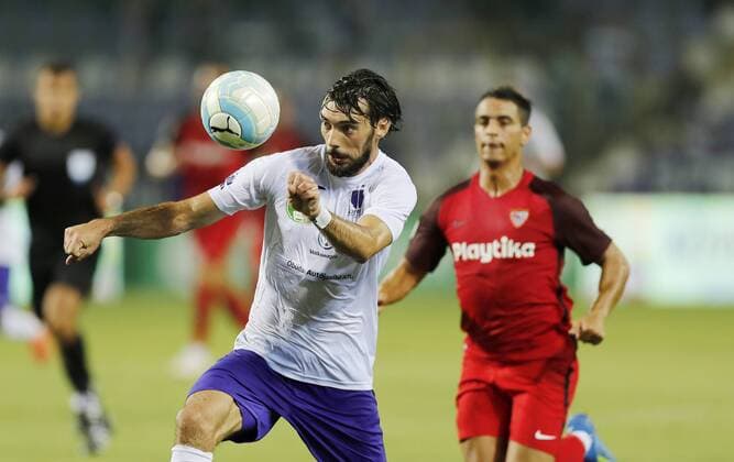 BUDAPEST, HUNGARY - AUGUST 2: (l-r) Mijusko Bojovic of Ujpest FC heads the ball in front of Wissam Ben Yedder of Sevilla FC during the UEFA Europa League Second Qualifying Round 2nd Leg match between Ujpest FC and Sevilla FC at Ferenc Szusza Stadium on August 2, 2018 in Budapest, Hungary. LaszloxSzirtesi 