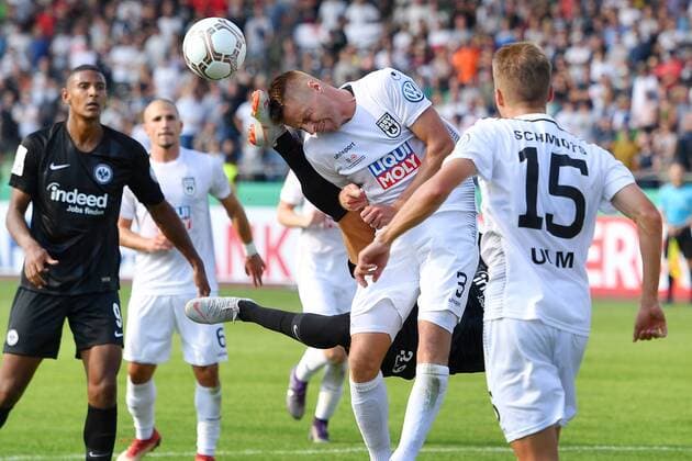 Goncalo Paciencia Eintracht Frankfurt meets Michael Schindele SSV ULM with the shoe on his face Foul Action Duel Penalty Scene 1 Round DFB Pokal SSV Ulm 1846 UL Eintracht Frankfurt F 2 1 at the Donau Stadium in Ulm on 18 08 2018 DFL REGULATIONS PROHIBIT ANY USE OF PHOTOGRAPHS AS IMAGE SEQUENCES AND OR QUASI VIDEO