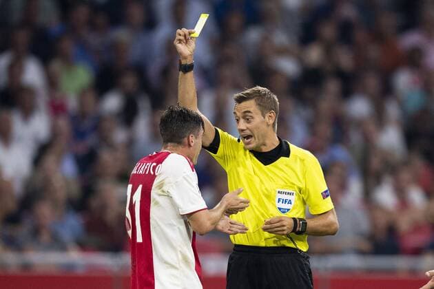 AMSTERDAM, Netherlands, 22-08-2018, football, season 2018 2019, Champions League Play-offs , Johan Cruijff ArenA , referee Clement Turpin gives Ajax player Nico Tagliafico the yellow card during the match Ajax - Dynamo Kiev . final score 3-1 Ajax - Dynamo Kiev  x2414356x
