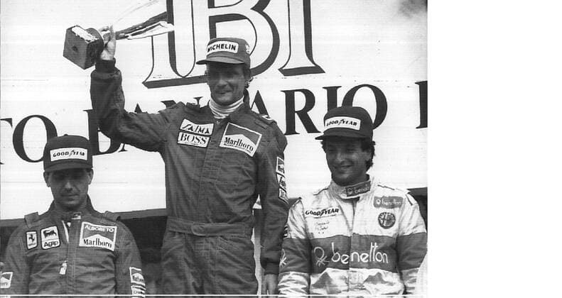 MONZA ---- NIKI LAUDA OF AUSTRIA (C) RAISES HIS CUP AFTER WINNING THE 55TH GRAND PRIX OF ITALY 09 09 84 . AT RIGHT ITALY S RICCARDO PATRESE , 3 RD, AND AT LEFT ITALY S MICHELE ALBORETO, 2ND PLACED. .JEP WST BELGA.  x85105218stx