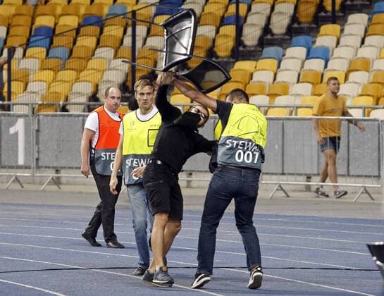August 28, 2018 - Kiev, Ukraine - Stewards try to stop a football hooligans throwing chairs to side of Ajax fans before begining the UEFA Champions League play-off, second leg soccer match between Ajax Amsterdam and FC Dynamo Kyiv, on the NSC Olimpiyskiy stadium in Kiev, Ukraine, 28 August,2018. Dinamo Kiev v Ajax - UEFA Champions League  - ZUMAn230 20180828_zaa_n230_373 Copyright: xStrx