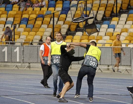 August 28, 2018 - Kiev, Ukraine - Stewards try to stop a football hooligans throwing chairs to side of Ajax fans before begining the UEFA Champions League play-off, second leg soccer match between Ajax Amsterdam and FC Dynamo Kyiv, on the NSC Olimpiyskiy stadium in Kiev, Ukraine, 28 August,2018. Dinamo Kiev v Ajax - UEFA Champions League  - ZUMAn230 20180828_zaa_n230_374 Copyright: xStrx