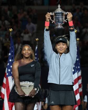 Winner Naomi Osaka extends her arms to the trophy Finalist Serena Williams is standing in the background of the award ceremony for the Womens Singles Final Final Copyright: xJuergenxHasenkopfx