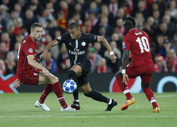PSG forward Kylian Mbappe runs through Liverpool midfielder Jordan Henderson (l) and Liverpool midfielder Sadio Mane (r) during the UEFA Champions League - Group C match at the Anfield Stadium, Liverpool. Picture date 18th September 2018. Picture credit should read: Andrew Yates Sportimage EDITORIAL USE ONLY. No use with unauthorised audio, video, data, fixture lists, club league logos or live services. Online in-match use limited to 120 images, no video emulation. No use in betting, games or single club league player publications.