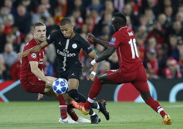 PSG forward Kylian Mbappe runs through Liverpool midfielder Jordan Henderson (l) and Liverpool midfielder Sadio Mane (r) during the UEFA Champions League - Group C match at the Anfield Stadium, Liverpool. Picture date 18th September 2018. Picture credit should read: Andrew Yates Sportimage EDITORIAL USE ONLY. No use with unauthorised audio, video, data, fixture lists, club league logos or live services. Online in-match use limited to 120 images, no video emulation. No use in betting, games or single club league player publications.