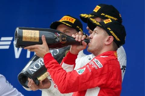 SOCHI, RUSSIA â€“ SEPTEMBER 30, 2018: Scuderia Ferrari driver Sebastian Vettel (front) of Germany, third-placed, drinks to celebrate during the 2018 Formula One Russian Grand Prix awarding ceremony at the Sochi Autodrom racing circuit. Yegor Aleyev TASS  TS092043