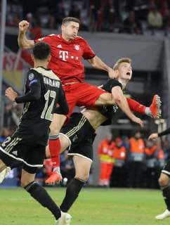 Champions League Match FC Bayern Munich Ajax Amsterdam 1 1 Robert Lewandowski jumps to the left Noussair Mazraoui to the right Kasper Dolberg DFL regulations prohibit any use of images Munich Bayern Germany Allianz Arena