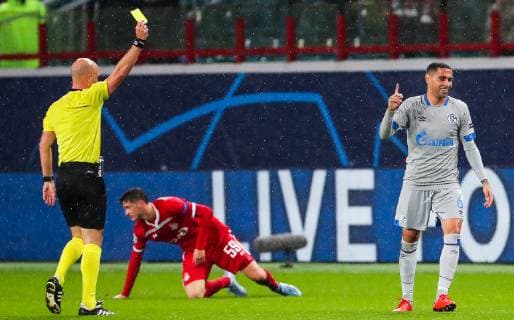 MOSCOW, RUSSIA â€“ OCTOBER 3, 2018: Referee Anthony Taylor (L) shows a yellow card to FC Schalke 04 s Omar Mascarell (R) their 2018 19 UEFA Champions League Group D Round 2 football match against FC Lokomotiv Moscow at RZD Arena Stadium. Pictured in the middle is Lokomotiv s Alexei Miranchuk. Sergei Fadeichev TASS  TS092684