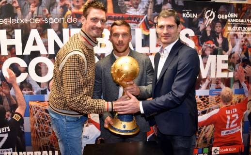 Lukas Podolski m Football World Champion and Ambassador of the Handball World Cup 2019 and the Handball World Champions of 2007 Carsten Lichtlein l and Henning Fritz r with trophy on 03 12 2018 in Cologne at the press conference for the Handball World Cup 2019 in the booth of the German Handball National Team of the World Cup 2007 The main round matches as well as the President s Cup of the Handball World Cup 2019 will be played in Cologne from 19 to 23 January 2019