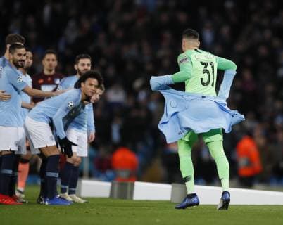 Ederson of Manchester City gets his glove stuck in his track suit top as he gets ready for the team group Mannschaftsbild Totale picture during the UEFA Champions League Group F match at the Etihad Stadium, Manchester. Picture date 12th December 2018. Picture credit should read: Simon Bellis Sportimage EDITORIAL USE ONLY. No use with unauthorised audio, video, data, fixture lists, club league logos or live services. Online in-match use limited to 120 images, no video emulation. No use in betting, games or single club league player publications.