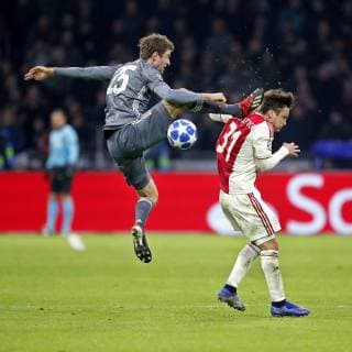 AMSTERDAM, Ajax - Bayern Munchen, football, Champions League Season 2018 2019, 12-12-2018, Johan Cruijff Arena . Bayern Munchen player Thomas Muller (L) with an karate kick to Ajax player Nicolas Tagliafico (R) during the game Ajax - Bayern . Ajax - Bayern  x2685832x