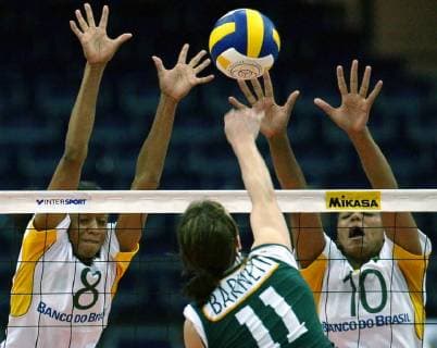 Tamsin Barnett center of Australia smashes against Valeska Menezes left and Welissa Gonzaga right of Brazil during the first round match of the Women s Volleyball World Championship Australia vs Brazil in Leipzig eastern Germany Sunday Sep 1 2002 Eckehard Schulz LEIPZIG DEU