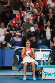 Belinda Bencic sits smiling on the chair during the break in the background the fans are dancing on the tribune Copyright: xJuergenxHasenkopfx
