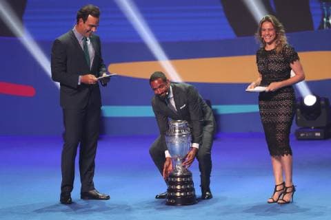 (190125) -- RIO DE JANEIRO, Jan. 25, 2019 (Xinhua) -- Chile s football player Jean Beausejour (C) puts down the trophy during the official draw ceremony of the CONMEBOL Copa America 2019 in Rio de Janeiro, Brazil, on Jan. 24, 2019. The draw result was Brazil, Bolivia, Venezuela and Peru in Group A, Argentina, Colombia, Paraguay and Qatar in Group B, Uruguay, Ecuador, Japan and Chile in Group C. The tournament will be held from June 14 to July 7 in 5 cities in Brazil. (Xinhua Li Ming) (SP)BRAZIL-RIO DE JANEIRO-CONMEBOL-COPA AMERICA 2019-DRAW