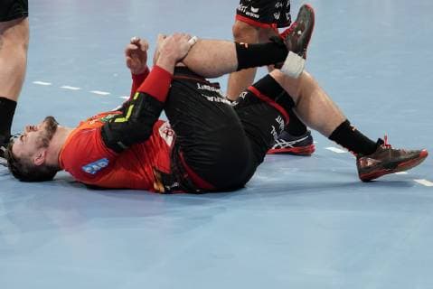 Jannik Kohlbacher RNL 80 keeps his right knee in pain after a foul racked with pain injured injury injured sporting injury action action scene handball champions league Rhine Neckar lions PGE Vive Kielce xozx