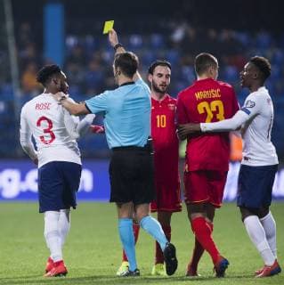 Sport Bilder des Tages 25th March 2019, Podgorica City Stadium, Podgorica, Montenegro; UEFA European Championships Qualification football, Montenegro versus England; Referee Aleksei Kulbakov of Belarus gives a yellow card to Danny Rose of England  ActionPlus12117788 NikolaxKrstic