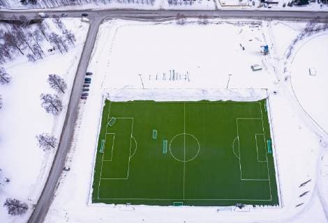 THEME PICTURE a green football field in the snow covered Norwegian countryside Lillehammer Norway on 2018 03 12 Lillehammer  EX_FEI