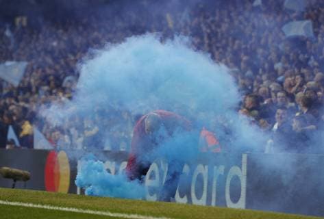 A steward removes a blue flare during the UEFA Champions League match at the Etihad Stadium, Manchester. Picture date: 17th April 2019. Picture credit should read: Darren Staples Sportimage EDITORIAL USE ONLY. No use with unauthorised audio, video, data, fixture lists, club league logos or live services. Online in-match use limited to 120 images, no video emulation. No use in betting, games or single club league player publications. SPI-0043-0011
