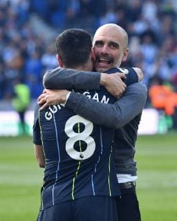 BRIGHTON, ENGLAND - MAY 12: Manchester City manager Pep Guardiola hugs Ilkay Gundogan (8) of Manchester City as they celebrate winning the Premier League title at full time with his team mates during the Premier League match between Brighton & Hove Albion and Manchester City at American Express Community Stadium on May 12, 2019 in Brighton, United Kingdom. SPO, SOC, FOC 