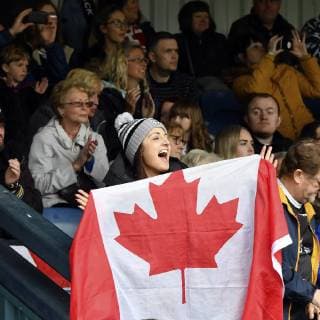 9th June 2019, Heywood Road stadium, Sale, Greater Manchester, England; Betfred Rugby Championship, Swinton versus Toronto Wolfpack; A Toronto Wolfpack fan waves her Canadian flag while enjoying the game at Swinton Lions  ActionPlus12142752 SimonxWhitehead