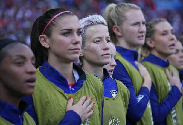 Members of the U.S. team, including Alex Morgan (2-L) and Megan Rapinoe (C) pause during the playing of the U.S. national anthem before the start of the FIFA Women s World Cup Group F match between the United States and Chile at the Parc des Princes near Paris on June 16, 2019. The U.S. team defeated Chile by the score of 3-0.  PAR201906167023 DAVIDxSILPA