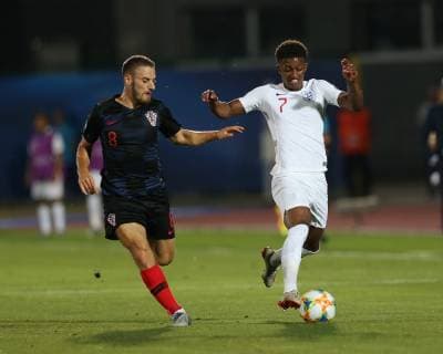 Nikola Vlasic of Croatia chases after Demarai Gray of England during the UEFA Under-21 Championship 2019 match at San Marino Stadium, Serravalle. Picture date: 24th June 2019. Picture credit should read: Jonathan Moscrop Sportimage EDITORIAL USE ONLY. No use with unauthorised audio, video, data, fixture lists, club league logos or live services. Online in-match use limited to 120 images, no video emulation. No use in betting, games or single club league player publications. SPI-0105-0016