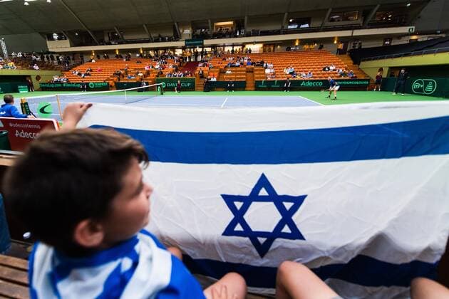 2019 Davis Cup Sweden v Israel 190913 A young spectator with an Israeli flag i seen in the foreground of Edan Leshem of Israel during the Davis Cup qualification tennis match between Sweden and Israel on September 13, 2019 in Stockholm,  Copyright: JOHANNAxLUNDBERG BB190913JL013
