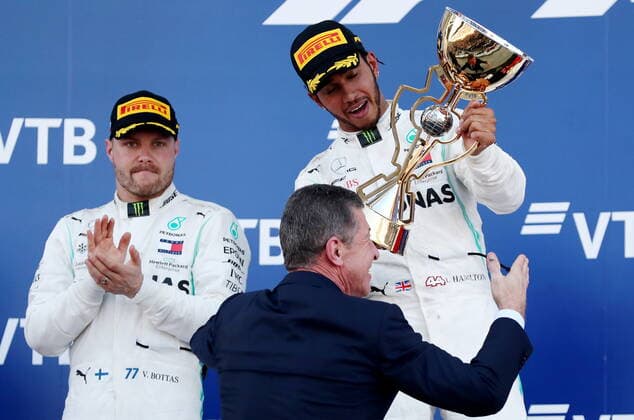 SOCHI, RUSSIA â€“ SEPTEMBER 29, 2019: Mercedes AMG Petronas F1 driver Valtteri Bottas of Finland, second-placed, looks on as Russia s Deputy Prime Minister Dmitry Kozak gives the trophy to Mercedes AMG Petronas F1 driver Lewis Hamilton of the United Kingdom, first-placed, during the 2019 Formula One Russian Grand Prix victory ceremony at the Sochi Autodrom racing circuit. Sergei Fadeichev TASS  TS0BCCE6