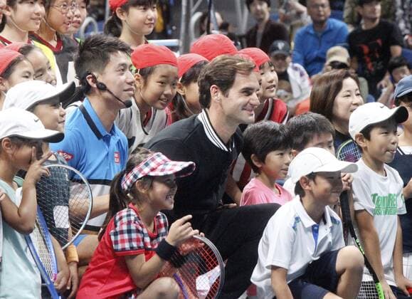 Federer and Nishikori at charity event Tennis players Roger Federer (C) and Kei Nishikori (C,L) pose for a photo with children at a charity event in Tokyo on Oct. 14, 2019. 