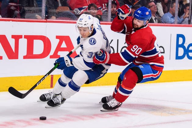 MONTREAL, QC - OCTOBER 15: Yanni Gourde (37) of the Tampa Bay Lightning skates away with the puck while being hold y Tomas Tatar (90) of the Montreal Canadiens during the third period of the NHL, Eishockey Herren, USA game between the Tampa Bay Lighting and the Montreal Canadiens on October 15, 2019, at the Bell Centre in Montreal, QC(Photo by Vincent Ethier Icon Sportswire) NHL: OCT 15 Lightning at Canadiens Icon1910152397