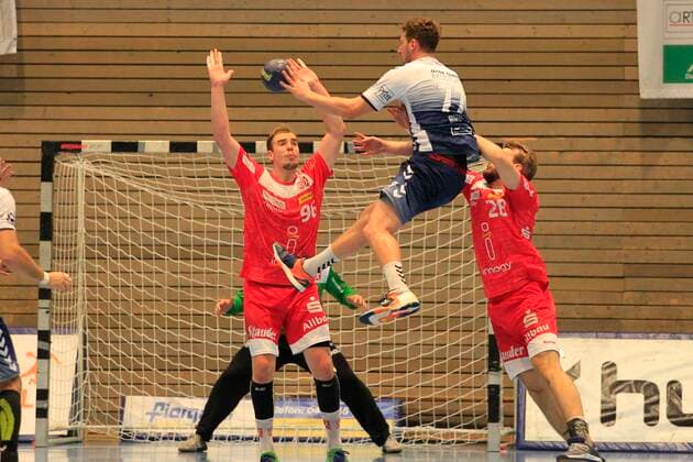 2 Bundesliga Handball VfL Luebeck Schwartau TUSEM Essen 20 10 2019, Hansehalle Luebeck, GER, 2 Bundesliga Handball VfL Luebeck Schwartau TUSEM Essen picture shows Jasper Bruhn VfL Luebeck Schwartau jumping on the goal of goalkeeper Fredrik Genz TUSEM Essen over Tim Zechel TUSEM Essen and Malte Seidel TUSEM Essen nordphotox xTauchnitz nph00059