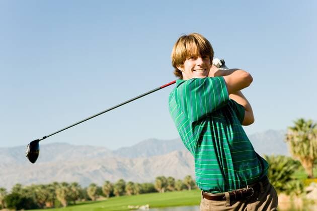 Young Man Swinging Golf Club 03B77010