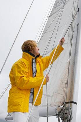 Young man standing on yacht in sea 03C05449