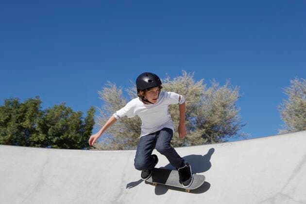 Teenage boy (16-17) skateboarding at skate park 03C06195