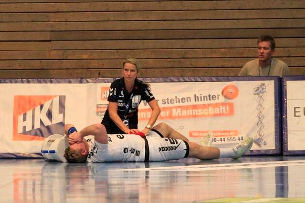 2 Bundesliga Handball VfL Luebeck Schwartau EHV Aue 21 11 2019, Hansehalle Luebeck, GER, 2 Bundesliga Handball VfL Luebeck Schwartau EHV Aue picture shows injured injury pain Sebastian Naumann EHV Aue is lying on the ground and is being treated nordphotox xTauchnitz nph00059