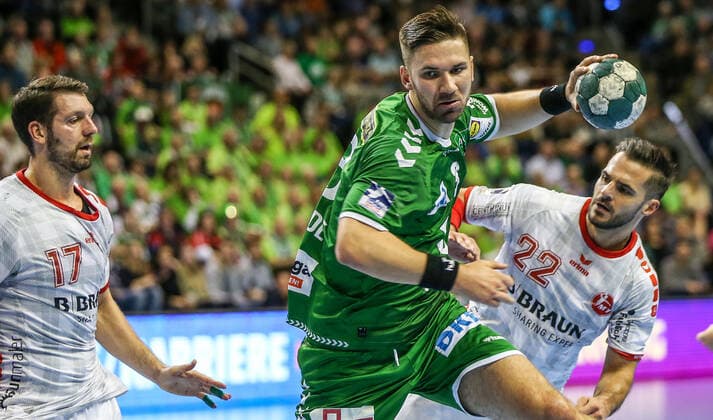 28 11 2019, Handball, 1 Bundesliga, 15 Spieltag, Füchse Berlin MT Melsungen, Max Schmeling Halle Berlins Fabian Wiede M throws the ball at the goal between Felix Danner l and Michael Allendorf r of MT Melsungen Handball 1 Bundesliga Füchse Berlin MT Melsungen