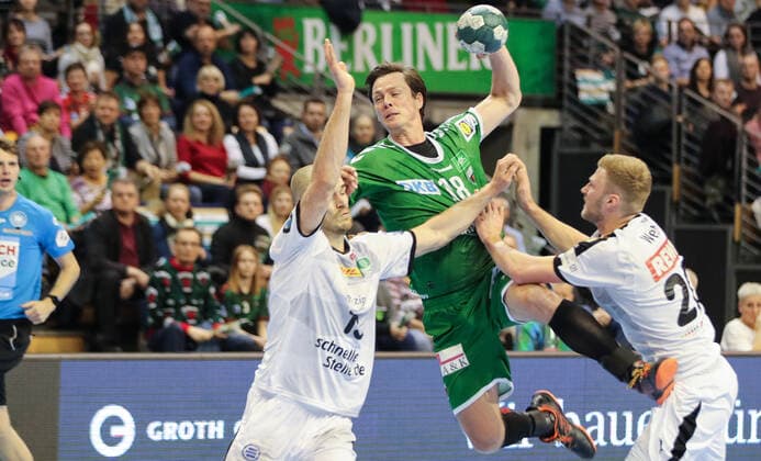 26 12 2019, Handball, 1 Bundesliga, 19 Matchday, Füchse Berlin SC DHfK Leipzig, Max Schmeling Halle Hans Lindberg M of Füchse Berlin throws the ball on goal by Leipzigs defense from Maximilian Janke l and Philipp Weber Handball 1 Bundesliga Füchse Berlin SC DHfK Leipzig