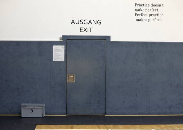 Door at Telekom Baskets ABZ training center Bonn Exit Entrance Lettering on the wall practice doesnt make perfect perfect practice makes perfect MR:N