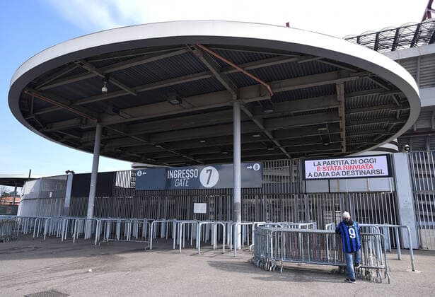 (200224) -- MILAN, Feb. 24, 2020 (Xinhua) -- A man stands at one of the entrances at the San Siro stadium in Milan, Italy, Feb. 23, 2020. Four Serie A football matches have all been suspended due to the increase of the novel coronavirus infections. (Photo by Federico Tardito Xinhua) (SP)ITALY-MILAN-FOOTBALL-SERIE A-DELAY 