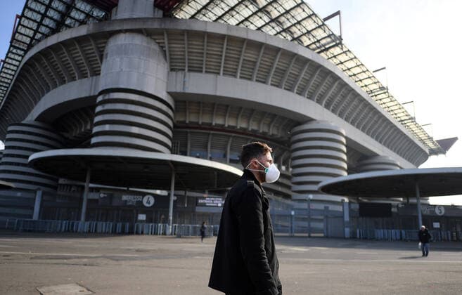 (200224) -- MILAN, Feb. 24, 2020 (Xinhua) -- A man wearing a face mask walks past the San Siro stadium in Milan, Italy, Feb. 23, 2020. Four Serie A football matches have all been suspended due to the increase of the novel coronavirus infections. (Photo by Federico Tardito Xinhua) (SP)ITALY-MILAN-FOOTBALL-SERIE A-DELAY 