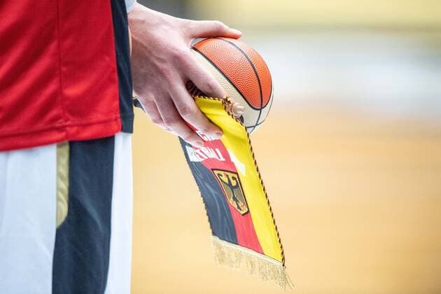 A German player holds the pennant and a small basketball in his hands, Feature, general, edge motif, Basketball EM Qualification, Group G, Germany GER France FRA 83 69, on 21 02 2020 in Vechta Germany Â