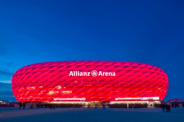 Spectators waiting for admission, illuminated Allianz Arena at the blue hour, Munich, Bavaria, Germany illuminated Allianz Arena