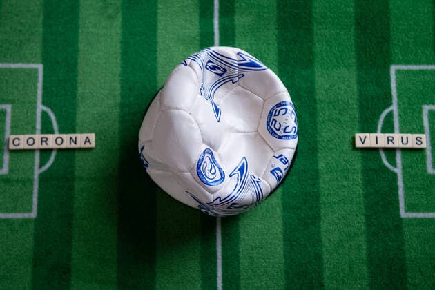 Germany 13 03 2020 Symbolic images Coronavirus The coronavirus causes cancellation of Bundesliga football matches, concerts or schools are closed Here A broken football with the word coronavirus on a football carpet Germany
