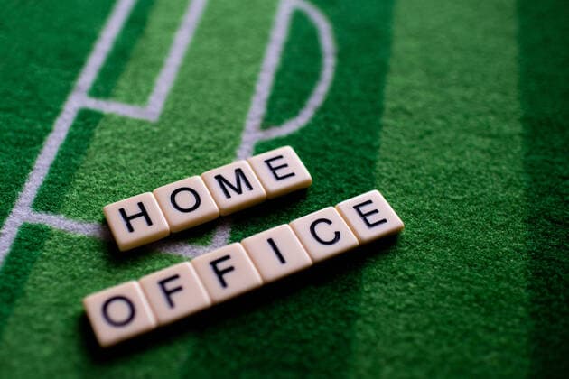 The corona virus Covid 19 causes event cancellations of, for example, football matches of Bundesliga professionals for an indefinite period of time and many effects, in the picture The word home office on a football carpet Germany