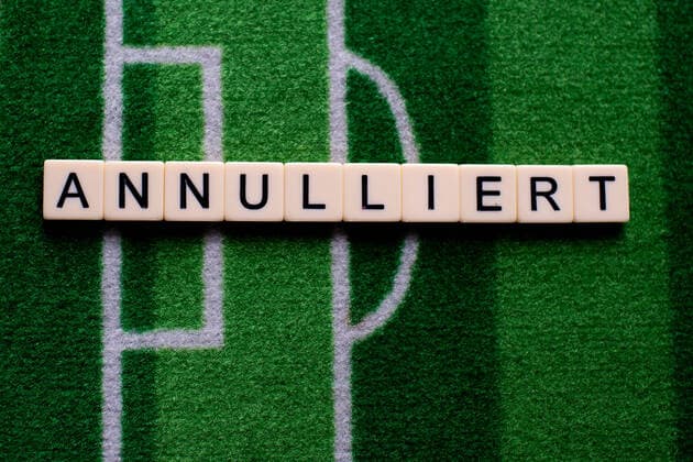 The corona virus Covid 19 causes event cancellations of, for example, football matches of Bundesliga professionals for an indefinite period of time and many effects, in the picture The word Annulled on a football carpet Germany