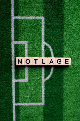 The coronavirus Covid 19 causes event cancellations of, for example, football matches of Bundesliga professionals for an indefinite period of time and many effects, in the picture The word emergency on a football carpet Germany