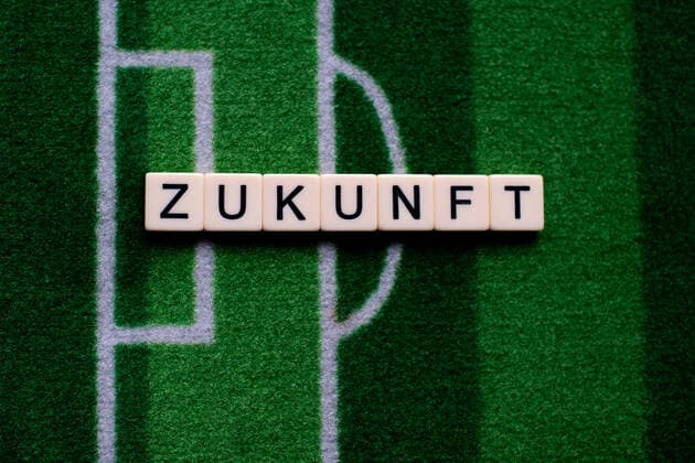The corona virus Covid 19 causes events such as Bundesliga football matches to be cancelled indefinitely and has many consequences, in the picture The word future on a football carpet Germany