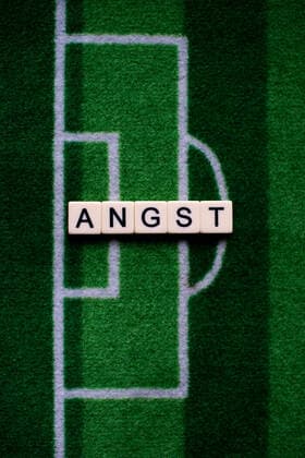 The corona virus Covid 19 causes events such as football matches of Bundesliga professionals to be cancelled indefinitely and has many consequences, in the picture The word fear on a football carpet Germany